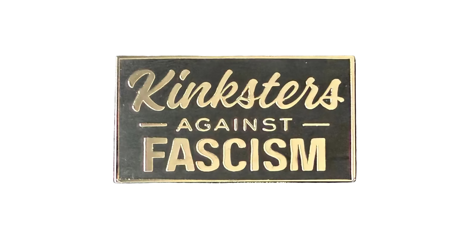 Close up of the Kinksters Against Fascism Enamel Pin - Black enamel with silver lettering and a thin silver border around the rectangle shape.